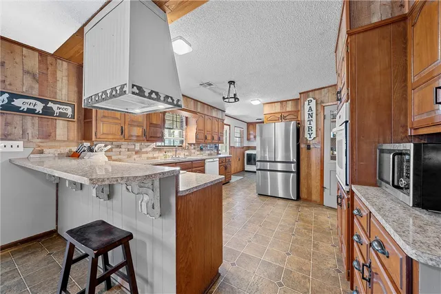 a kitchen with stainless steel appliances granite countertop a sink stove and refrigerator
