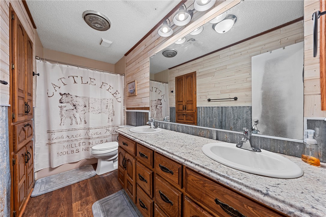 126 Cr 173 Road Marlin, TX 76661 - Photo 16 of 48 a bathroom with a granite countertop double vanity sink mirror and toilet