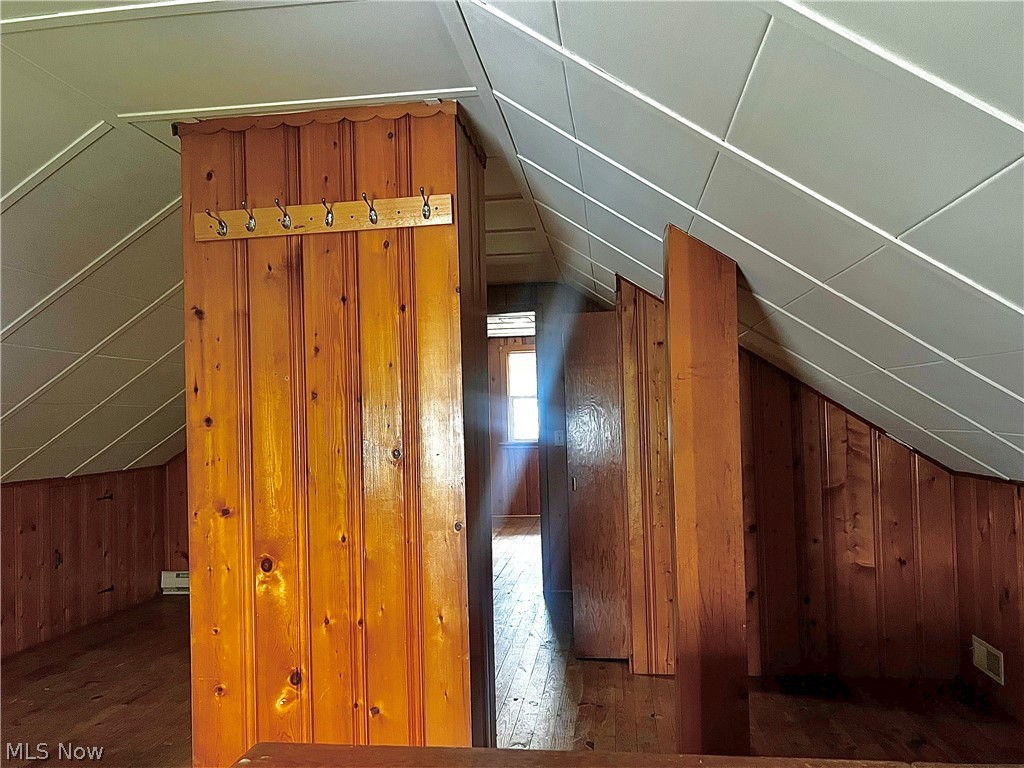 67 Forbes Road Bedford, OH 44146 - Photo 15 of 20 Additional living space with wood walls, dark wood-style flooring, and lofted ceiling