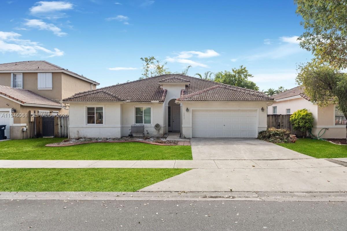 a front view of a house with a yard and garage