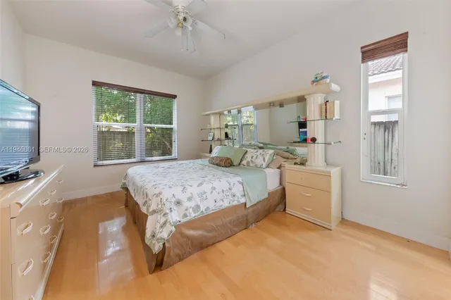 a bedroom with a large bed and a flat tv screen on dresser