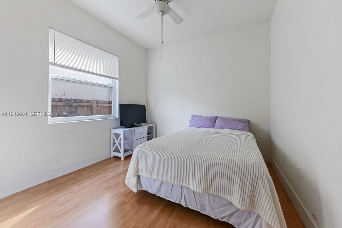 15932 Southwest 146th Terrace Miami, FL 33196 - Photo 17 of 25 a bedroom with a bed and wooden floor
