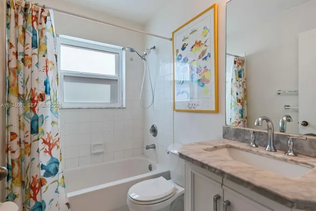 a bathroom with a granite countertop sink a toilet and a bathtub