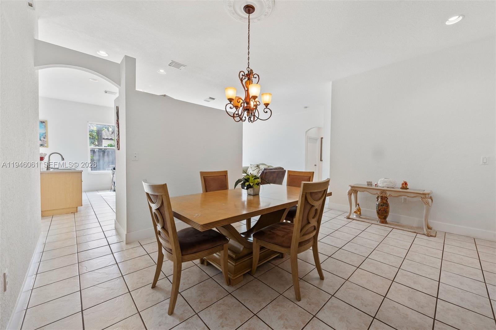 15932 Southwest 146th Terrace Miami, FL 33196 - Photo 4 of 25 a dining room filled a chandelier and kitchen view