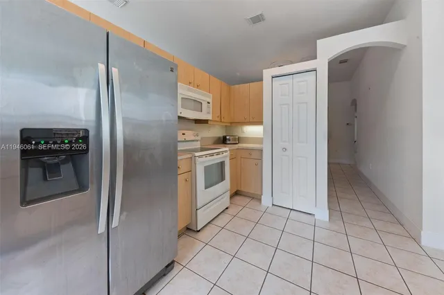 a kitchen with white cabinets a refrigerator and a stove