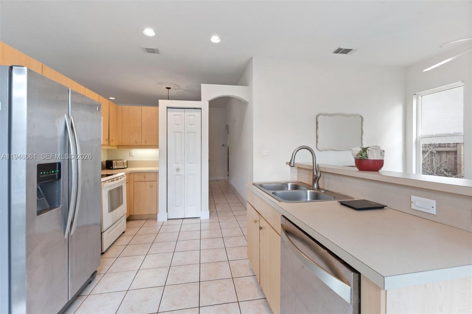 15932 Southwest 146th Terrace Miami, FL 33196 - Photo 9 of 25 a kitchen with a sink refrigerator and cabinets