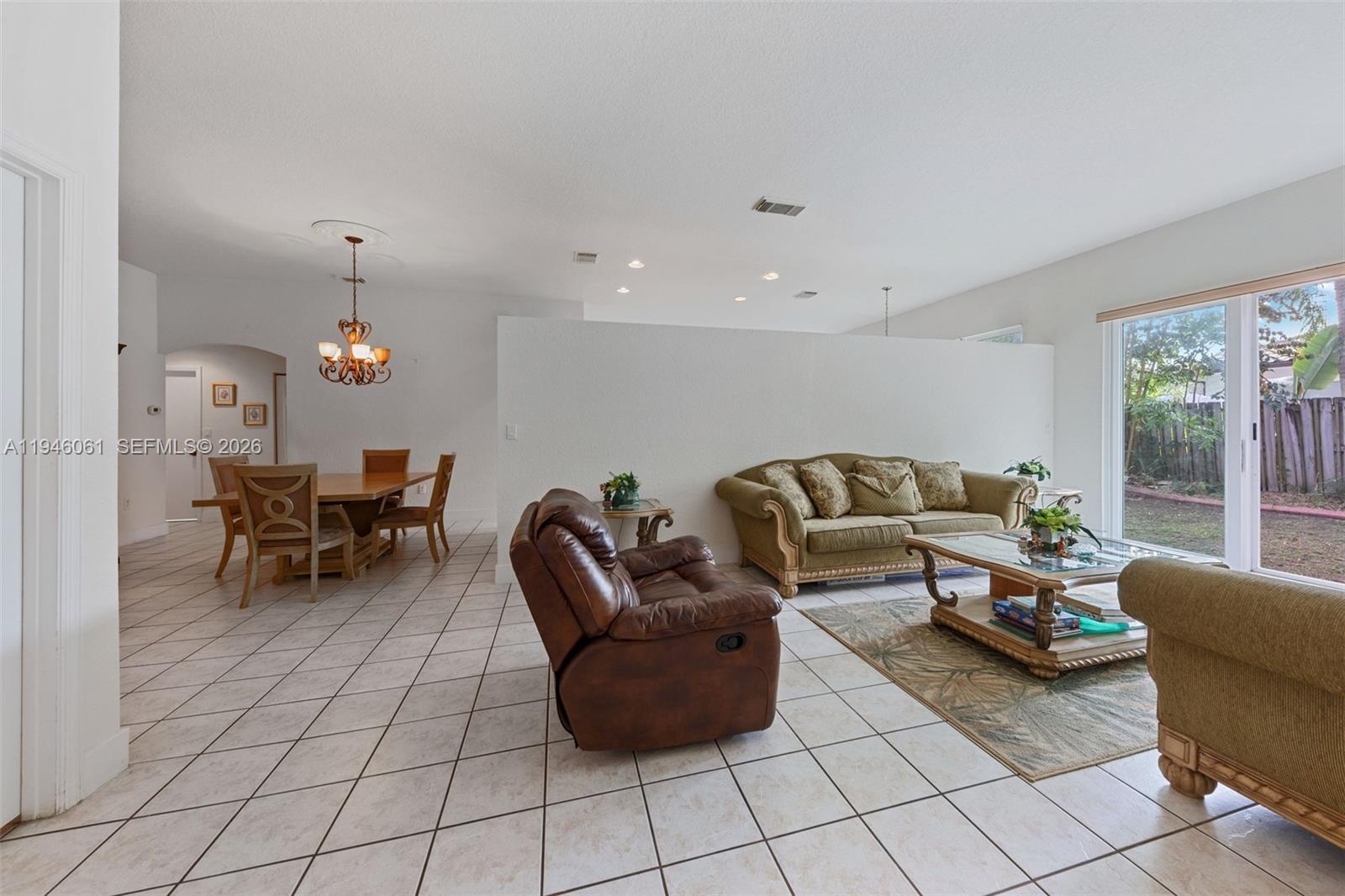 15932 Southwest 146th Terrace Miami, FL 33196 - Photo 10 of 25 a living room with furniture and a chandelier