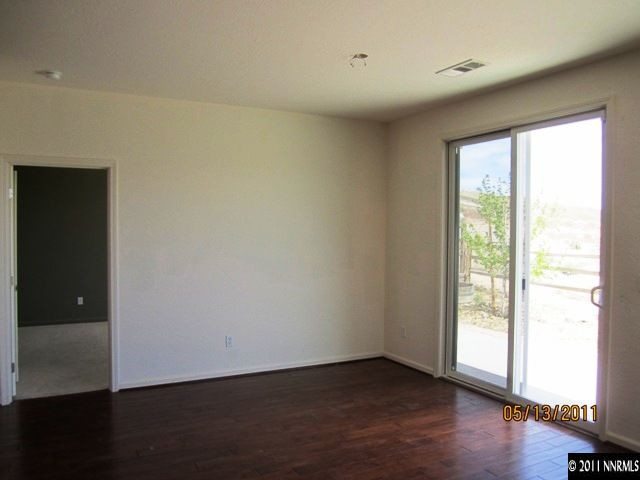 1226 Firefly Court Reno, NV 89523 - Photo 7 of 13 a view of an empty room with wooden floor and a window