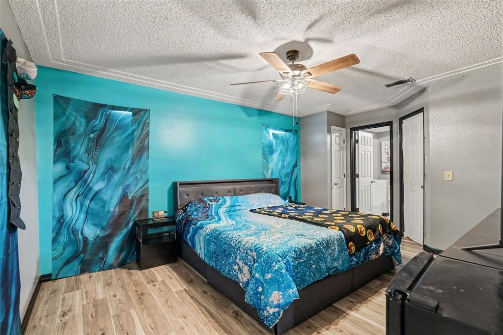 4156 Weldon Avenue Spring Hill, FL 34609 - Photo 14 of 26 a bedroom with a bed and a chandelier
