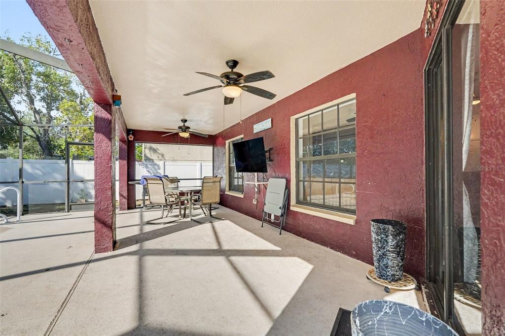 4156 Weldon Avenue Spring Hill, FL 34609 - Photo 4 of 26 a living room with furniture a flat screen tv and a floor to ceiling window