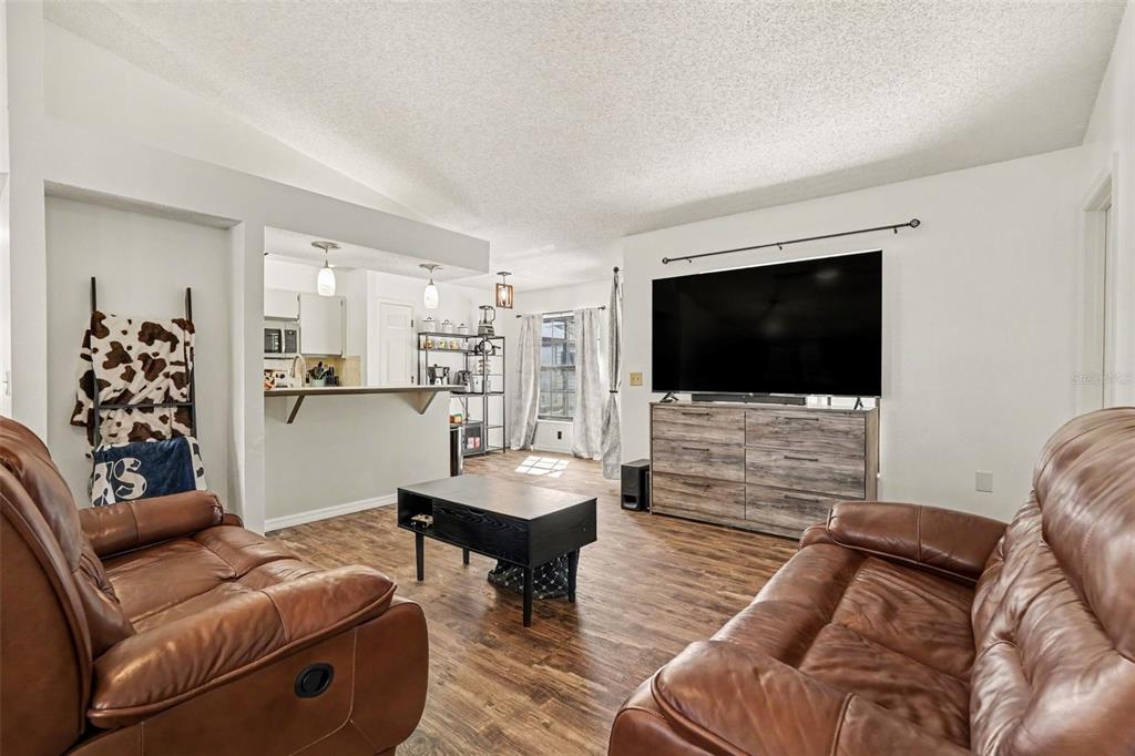 4156 Weldon Avenue Spring Hill, FL 34609 - Photo 10 of 26 a living room with furniture and a flat screen tv