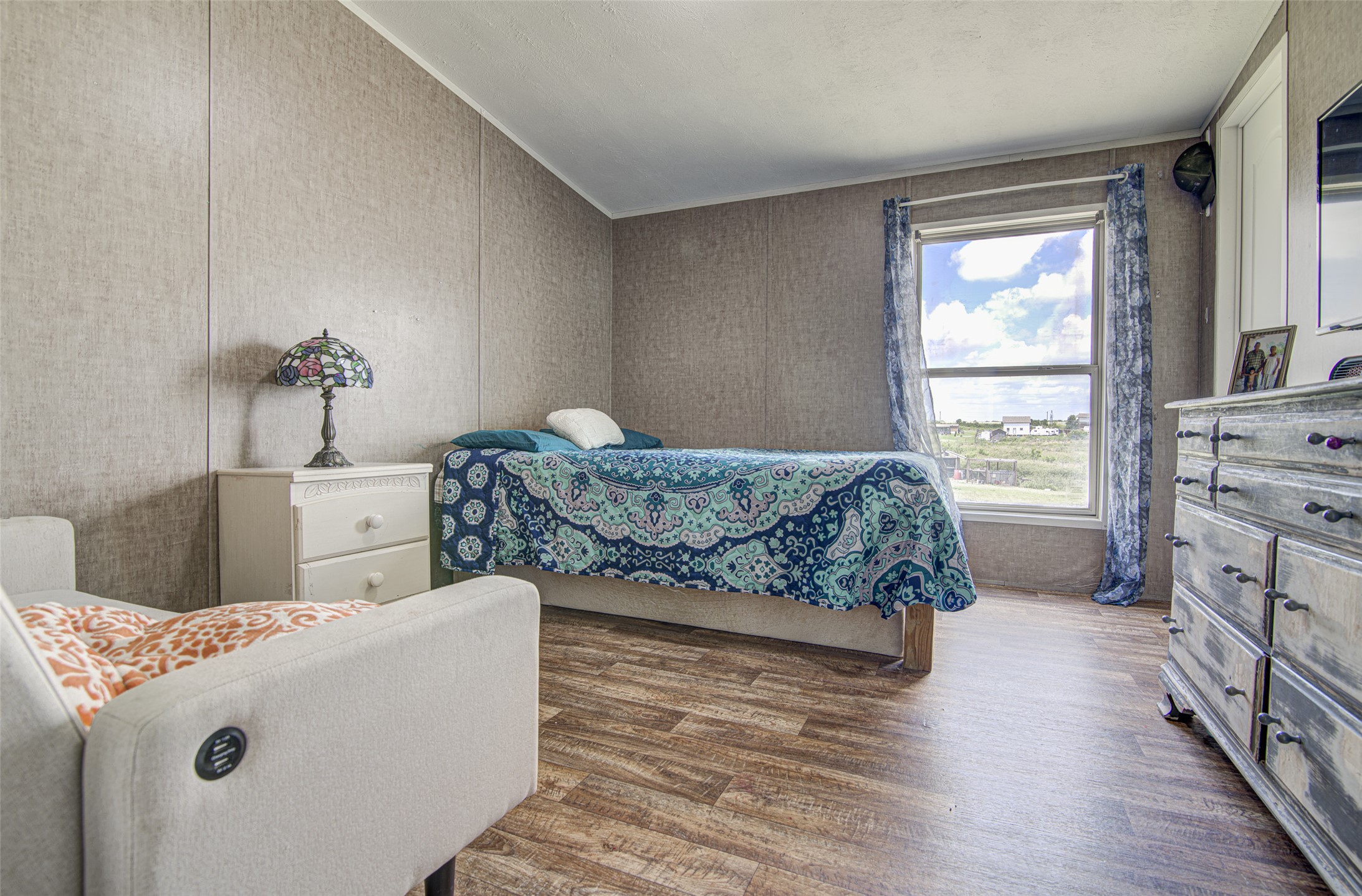 445 Rancho Linda Drive Lockhart, TX 78644 - Photo 21 of 26 Natural light floods this inviting bedroom with durable wood flooring and a picturesque window view.