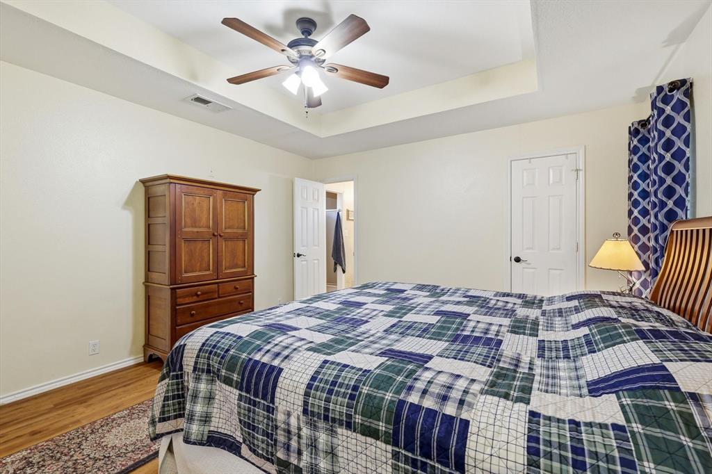 6000 Jackson Road Krum, TX 76249 - Photo 13 of 40 a bedroom with a bed and a chandelier