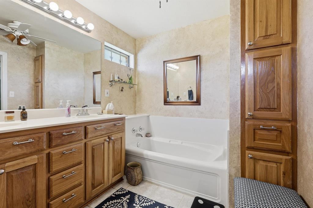 6000 Jackson Road Krum, TX 76249 - Photo 15 of 40 a bathroom with a tub sink and a mirror