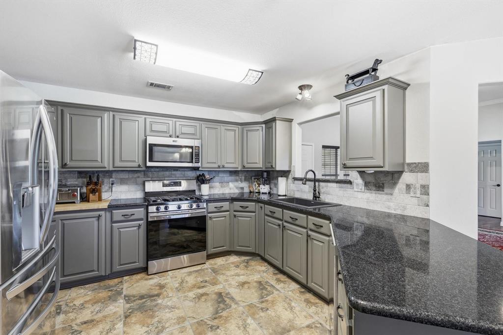 6000 Jackson Road Krum, TX 76249 - Photo 8 of 40 a kitchen with stainless steel appliances granite countertop a sink stove and refrigerator