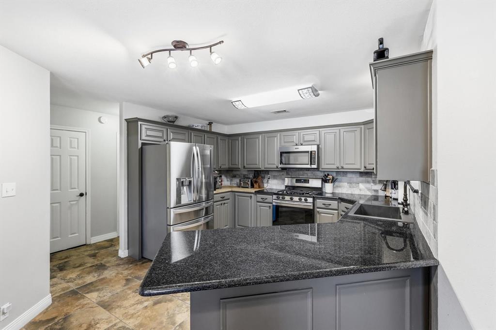 6000 Jackson Road Krum, TX 76249 - Photo 9 of 40 a kitchen with stainless steel appliances granite countertop a sink refrigerator and cabinets