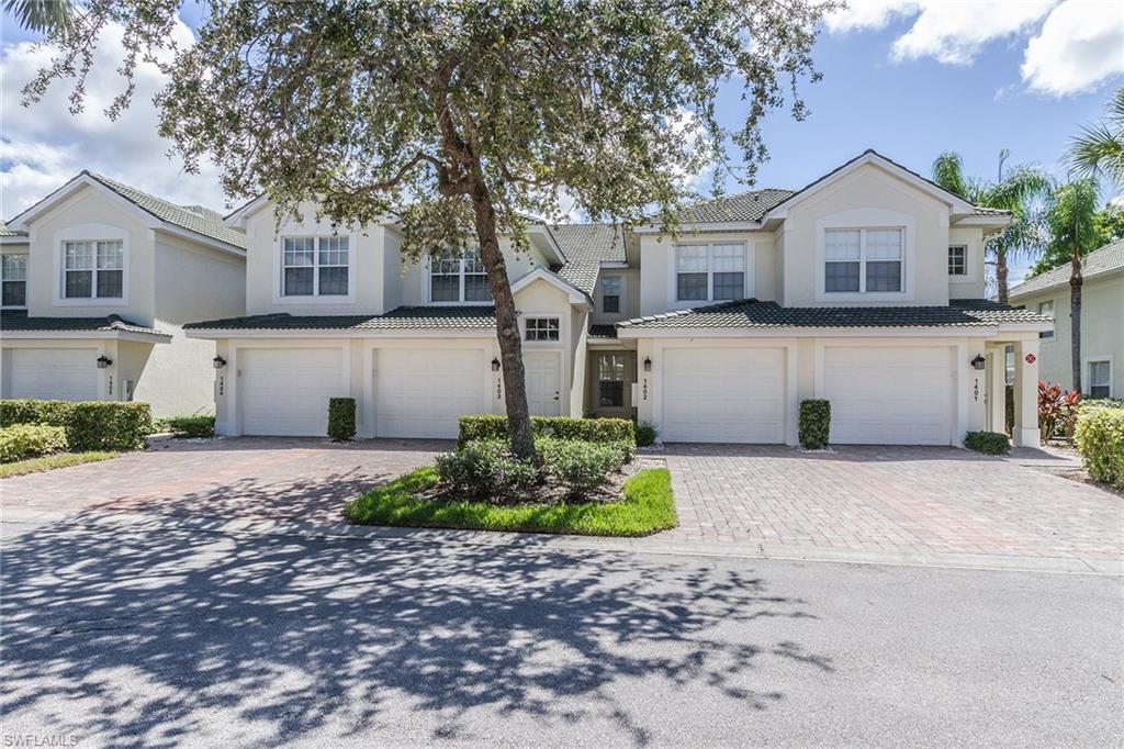 23770 Clear Spring Court, Unit 1402 Estero, FL 34135 - Photo 1 of 17 a front view of a house with a yard and a garage