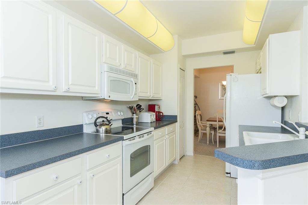 23770 Clear Spring Court, Unit 1402 Estero, FL 34135 - Photo 4 of 17 a kitchen with white cabinets and sink