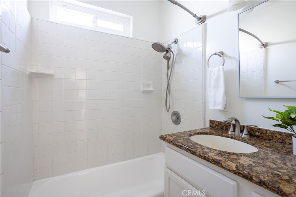 1514 Pilgrim Way Monrovia, CA 91016 - Photo 23 of 47 a bathroom with a granite countertop sink a mirror and a shower