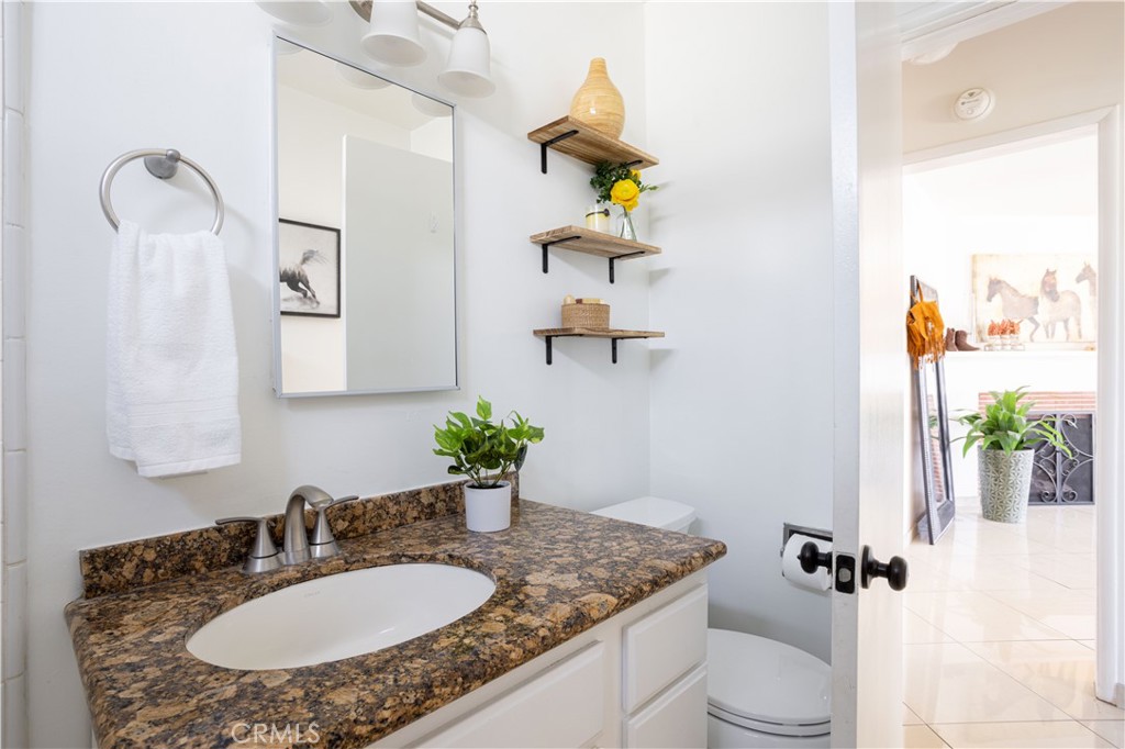 1514 Pilgrim Way Monrovia, CA 91016 - Photo 24 of 47 a bathroom with a granite countertop sink a toilet and mirror