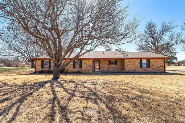 a front view of a house with a yard covered in snow