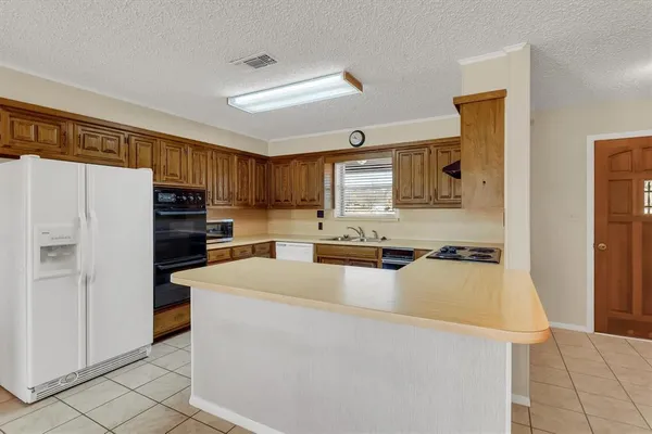 a kitchen with a stove a sink a microwave and cabinets