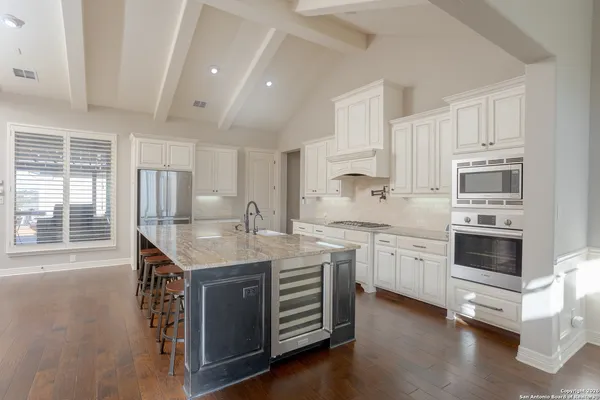 a kitchen with granite countertop a sink appliances cabinets and counter space