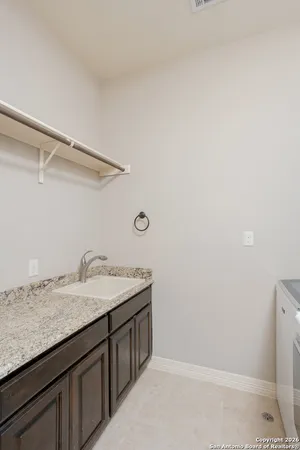 a bathroom with a granite countertop sink and white cabinets