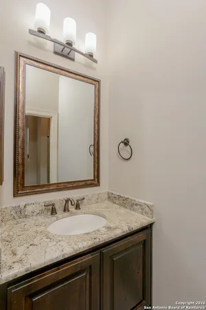 a bathroom with a granite countertop sink and a mirror