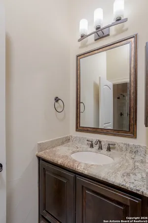 a bathroom with a granite countertop sink and a mirror
