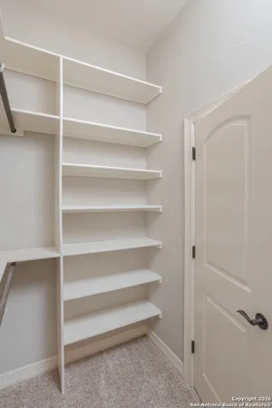 a view of walk in closet with empty racks