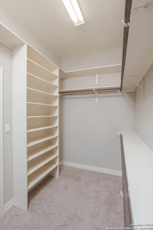 a view of walk in closet with empty racks