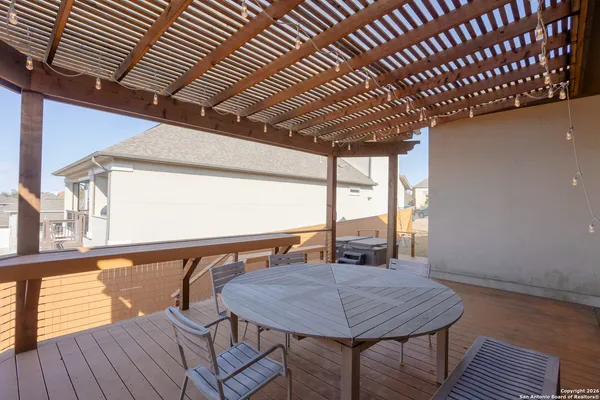 a roof deck with wooden floor and fence