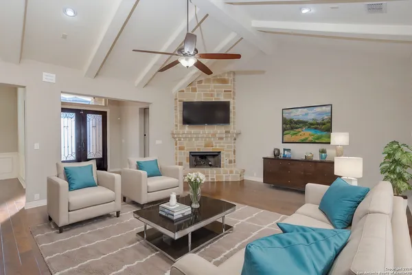 a living room with furniture a fireplace and a flat screen tv