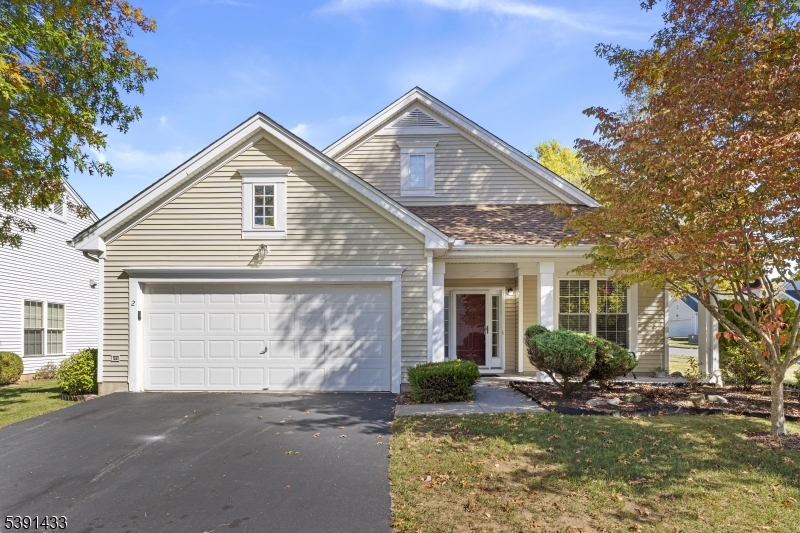 a front view of a house with garden and garage
