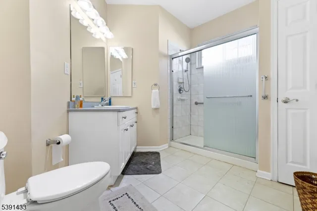 a bathroom with a sink a toilet a mirror and shower