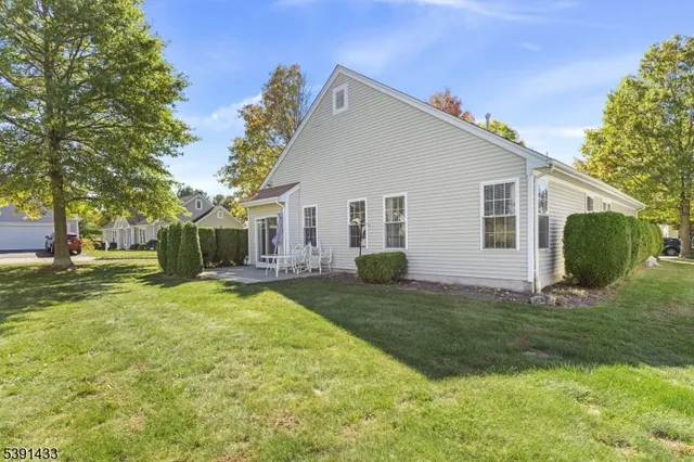 a front view of a building with a garden and plants