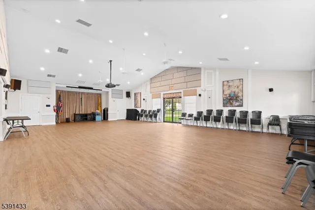 a kitchen with stainless steel appliances granite countertop a refrigerator a sink dishwasher a stove and white countertops with wooden floor