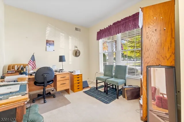 a view of a workspace with furniture and a window