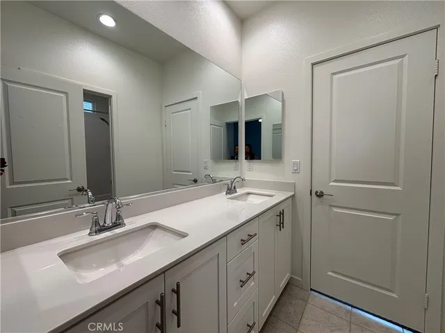 a bathroom with a double vanity sink and mirror