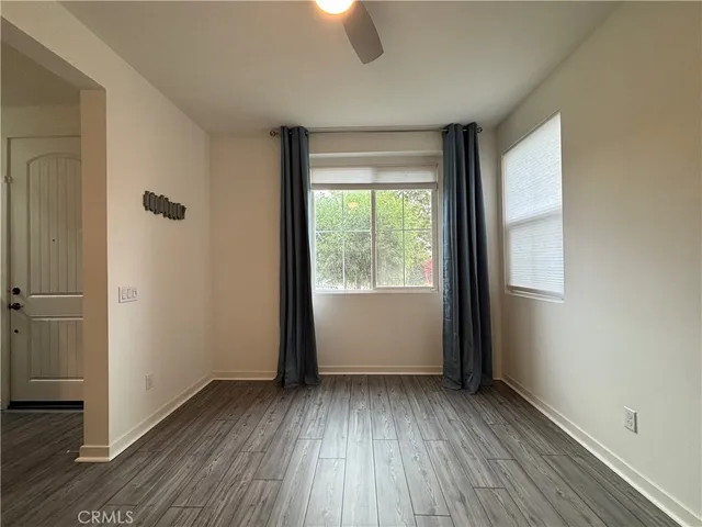 an empty room with wooden floor and window