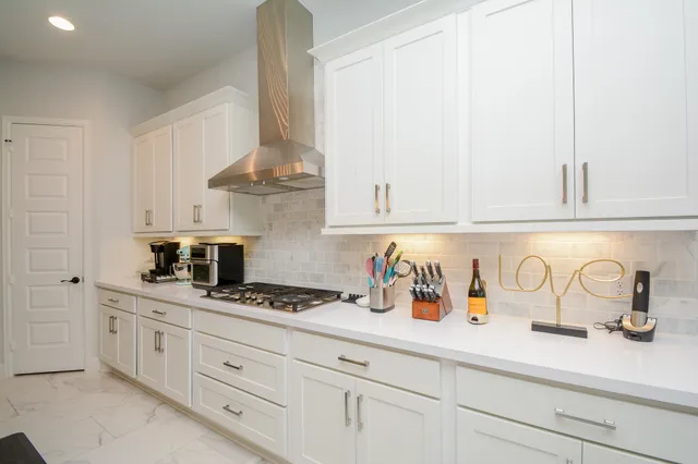 a kitchen with white cabinets and sink
