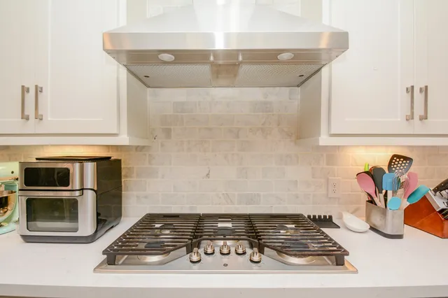 a stove top oven sitting inside of a kitchen
