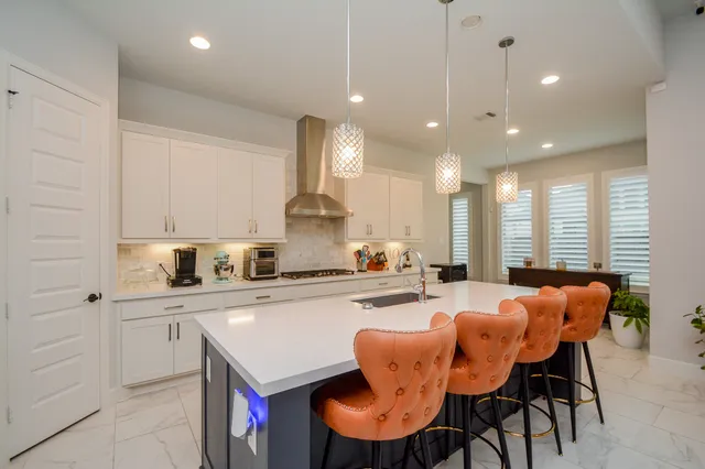 a kitchen with stainless steel appliances kitchen island granite countertop a sink and chairs
