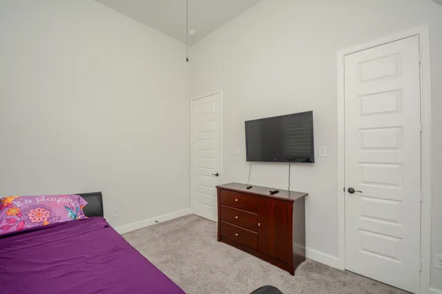 a bedroom with a bed and a flat screen tv