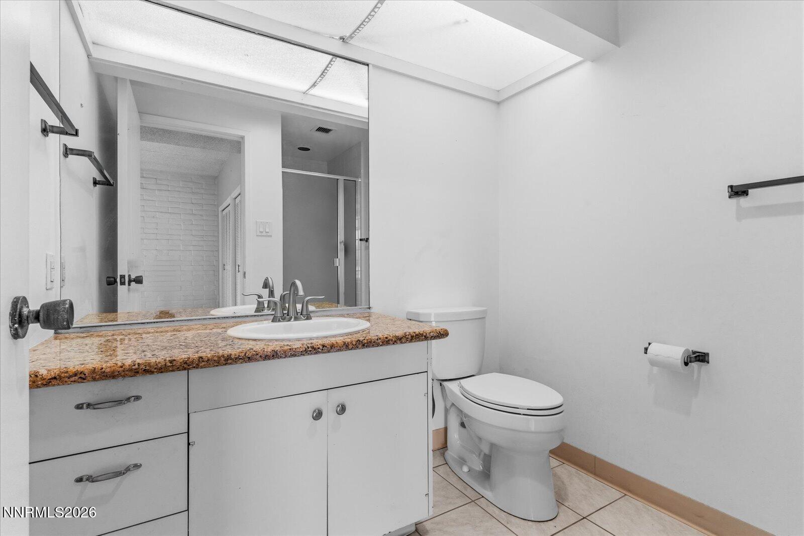 1200 Riverside Drive, Unit 1229 Reno, NV 89503 - Photo 31 of 51 a bathroom with a granite countertop sink a toilet and a mirror