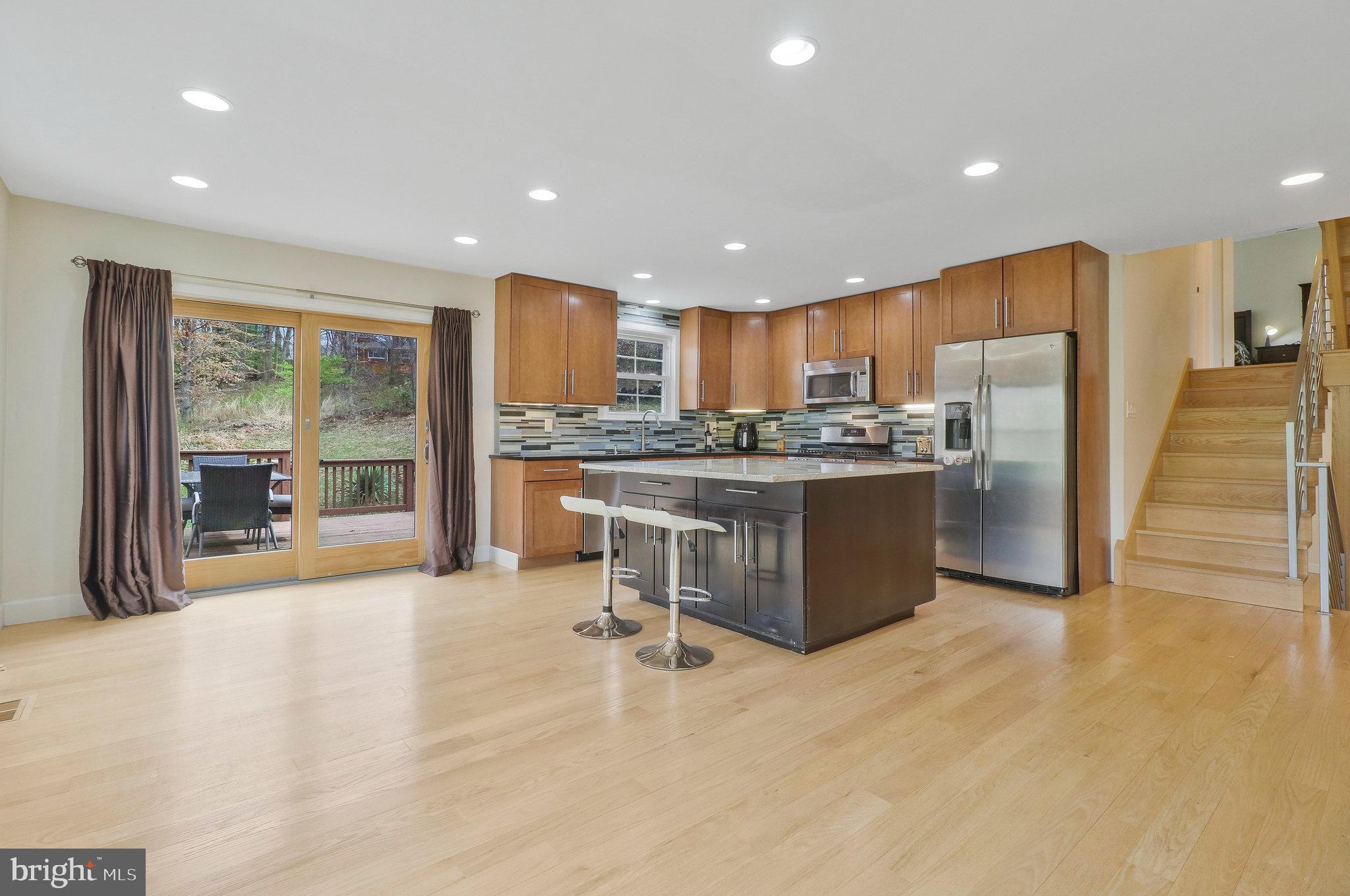 8543 Howell Road Bethesda, MD 20817 - Photo 7 of 24 a kitchen with stainless steel appliances granite countertop a stove a refrigerator a oven a sink and a island with wooden floor