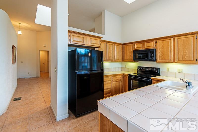 3307 Current Court Reno, NV 89509 - Photo 7 of 19 a kitchen with a refrigerator a stove top oven a sink and dishwasher