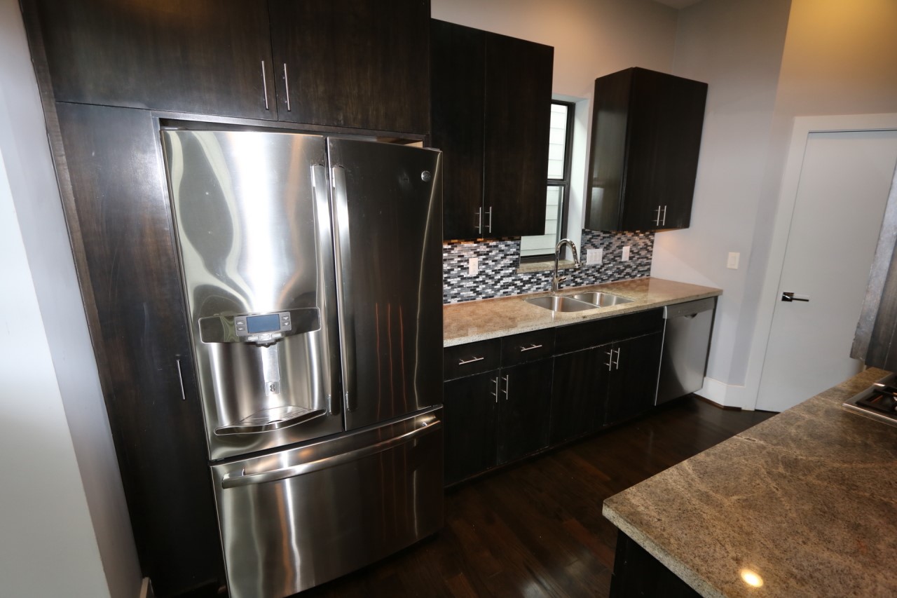 2103 Hadley Street Houston, TX 77003 - Photo 10 of 19 a kitchen with stainless steel appliances wooden floor sink and refrigerator