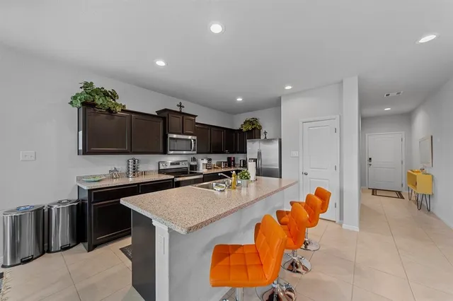 a kitchen with stainless steel appliances granite countertop a sink counter space and a stove top oven